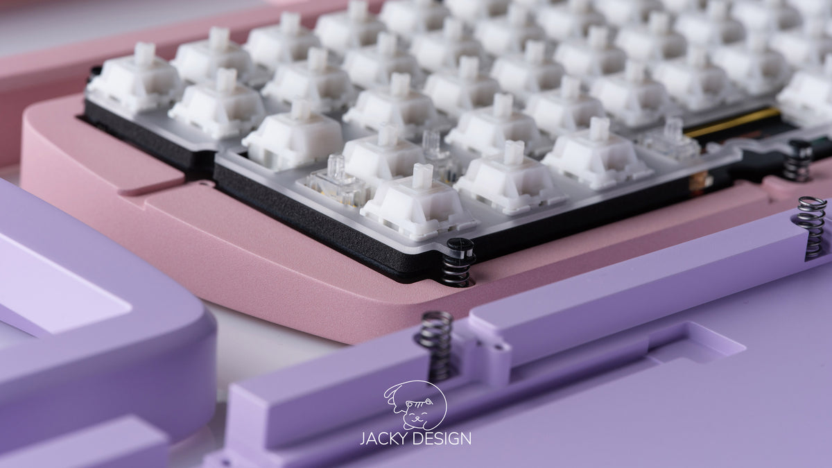 lockup photo featuring both lavender and mist pink case bottoms featuring some keycaps and parts
