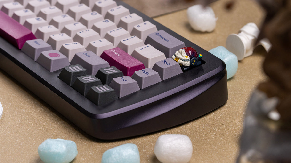 violet keyboard right side view featuring some keycaps and an artisan keycap