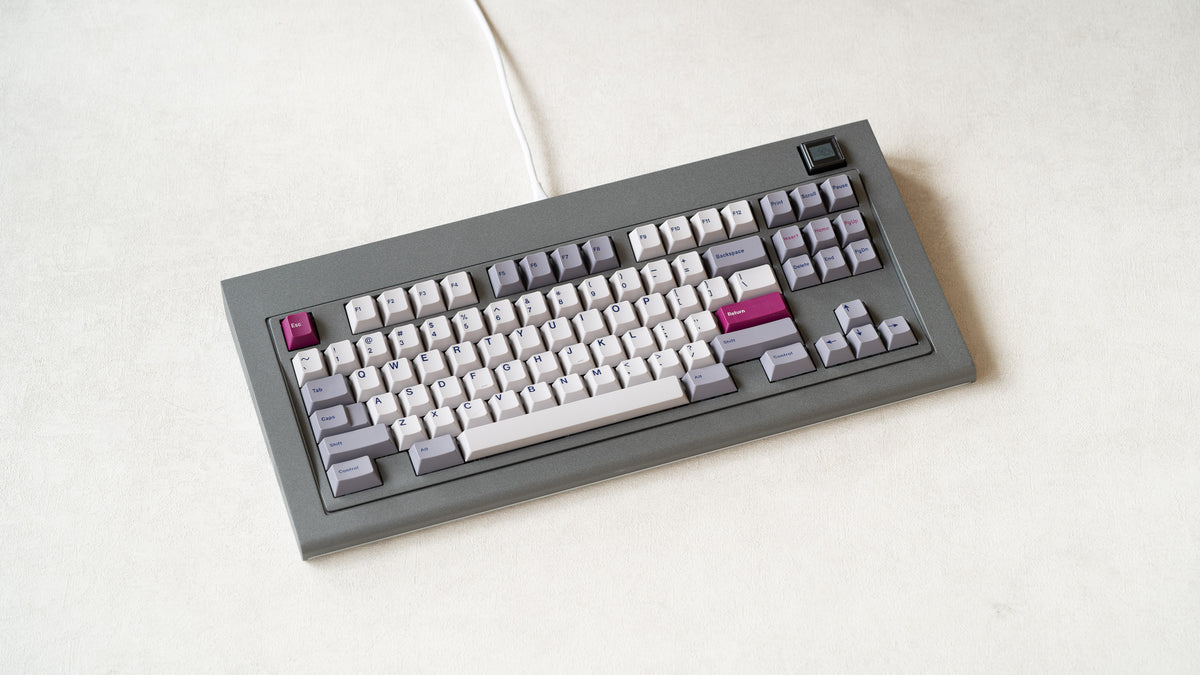  Industrial grey Model OLED at an angle featuring white light purple, and magenta keycaps 