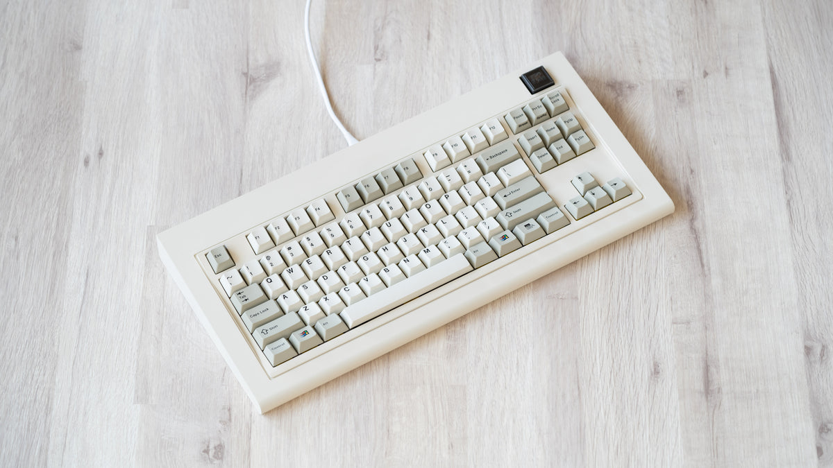 Vintage beige Model OLED at an angle featuring beige and white keycaps with black lettering 