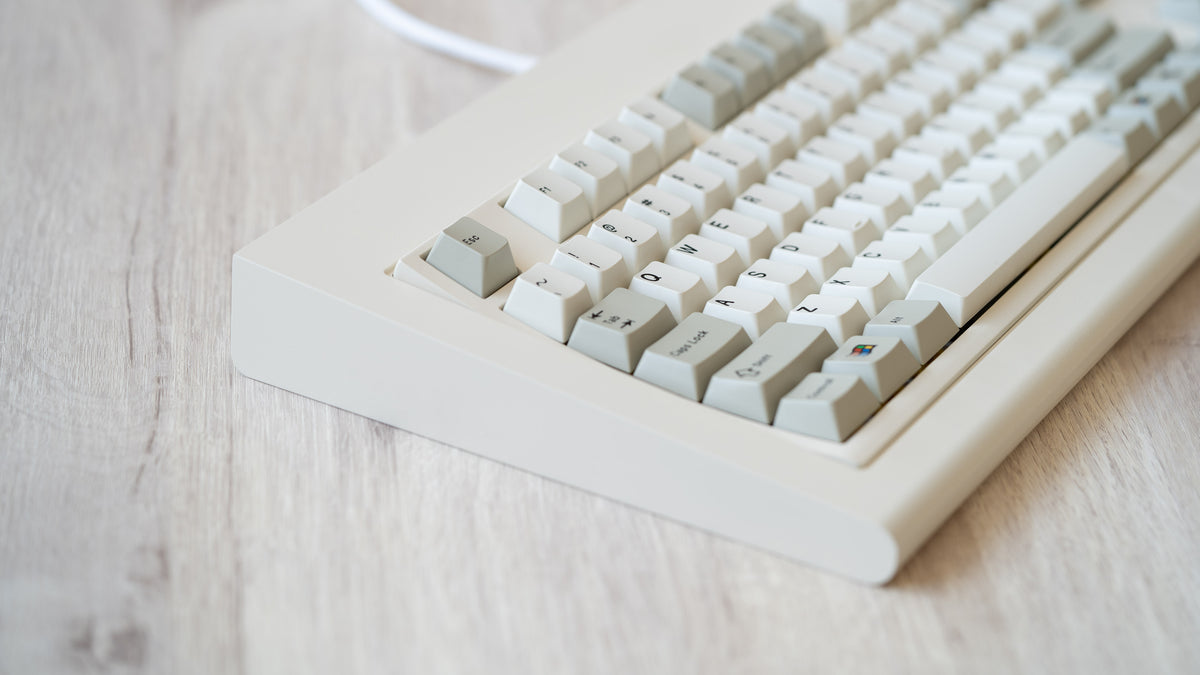  Vintage beige Model OLED zoomed in on left featuring beige and white keycaps with black lettering 