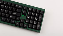 Load image into Gallery viewer, green case featuring white on black keycaps angled right side