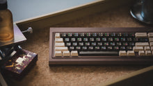 Load image into Gallery viewer, curve 65 keyboard in brown on cork angled