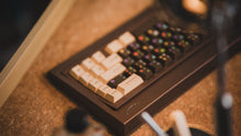 Load image into Gallery viewer, curve 65 keyboard in brown on cork back view blurry