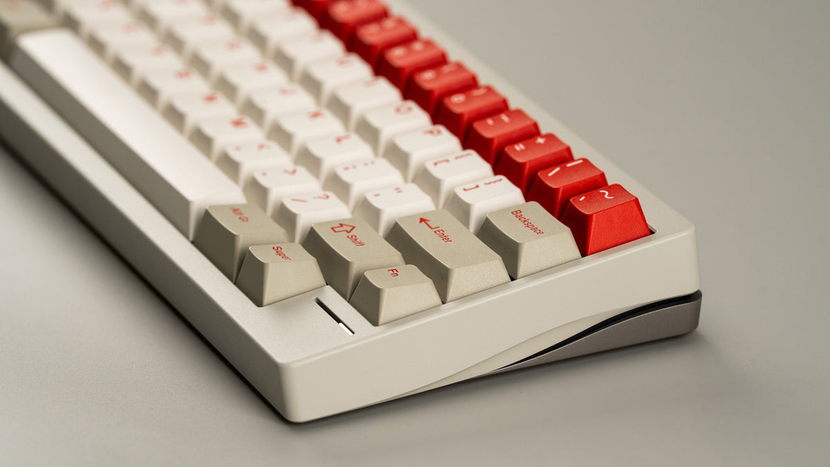 Close-up of a mechanical keyboard with white and red keys on a gray background 