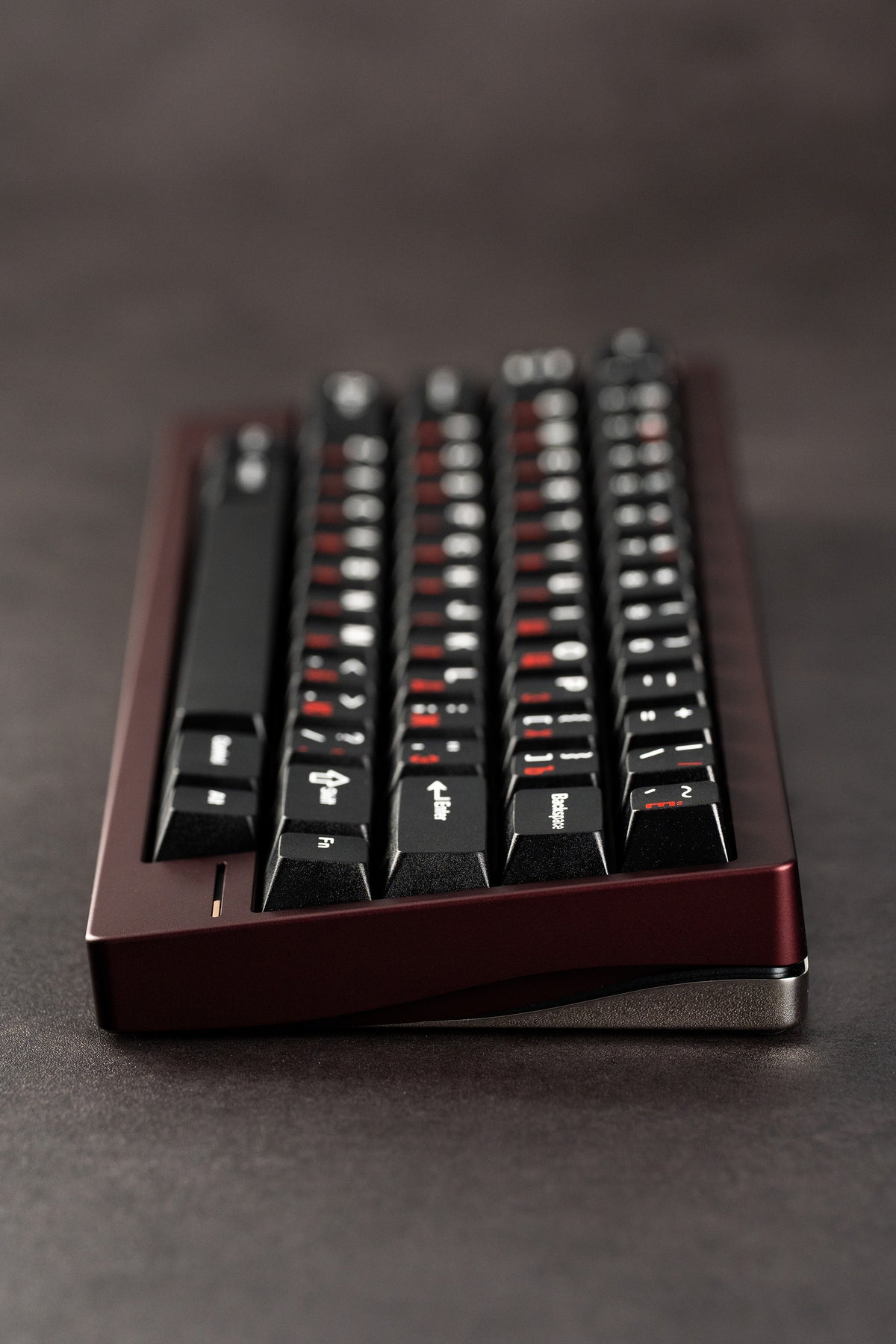  Black keyboard with red accents on a dark surface 
