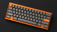 Load image into Gallery viewer, render of GMK CYL Carbon R3 on an orange keyboard angled