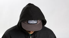 Load image into Gallery viewer, Model with hood up looking down wearing a Grey East Coast Keyboard Mafia hat