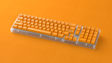 Load image into Gallery viewer, render of GMK CYL ADA on a clear phideas on orange background angled