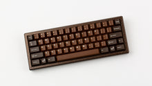 Load image into Gallery viewer, GMK CYL Chocolatier keycaps on dark brown hammered-texture 60% keyboard, top-down angled view
