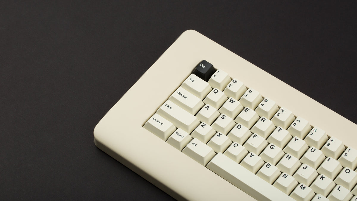  GMK CYL Creme on a beige keyboard close up on left side angled 