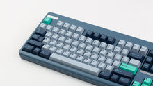 Load image into Gallery viewer, GMK CYL Hammerhead Small Batch keycaps on slate blue TKL keyboard, angled view from upper left showing full board with teal Esc accent