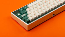 Load image into Gallery viewer, GMK CYL Kaiju R3 hiragana base keycaps rear angle on silver 65% keyboard, orange background