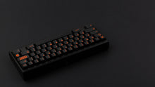 Load image into Gallery viewer, GMK CYL Kaiju R3 dark base keycaps on black 65% keyboard, rear angle on dark background