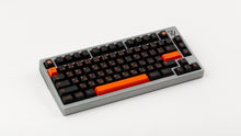 Load image into Gallery viewer, GMK CYL Kaiju R3 dark base keycaps on silver 75% keyboard, full board angled view