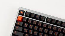 Load image into Gallery viewer, GMK CYL Kaiju R3 dark base keycaps close-up of left corner, orange Esc and function row on silver keyboard