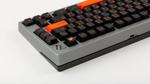 Load image into Gallery viewer, GMK CYL Kaiju R3 dark base keycaps rear angle on silver 75% keyboard showing orange enter