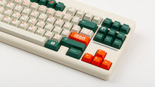 Load image into Gallery viewer, GMK CYL Kaiju R3 hiragana base keycaps close-up of right side, orange enter and arrows on beige keyboard