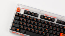 Load image into Gallery viewer, GMK CYL Kaiju R3 dark base keycaps close-up of left side with orange Esc on clear keyboard