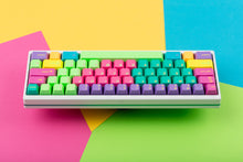 Load image into Gallery viewer, GMK CYL Windbreaker keycaps on white 65% keyboard, rear view on colorful background
