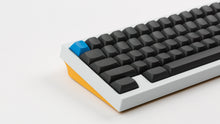 Load image into Gallery viewer, MTNU Graphite on a white an yellow keyboard close up on left