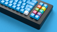 Load image into Gallery viewer, render of Unobtanium Blue on a black NK Plus keyboard close up on left side back view on a blue background