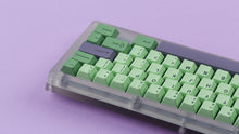 Load image into Gallery viewer, GMK CYL Zooted keycaps on translucent smoke 60% keyboard, close-up of top-right corner showing function row and purple accent keys against a lavender background