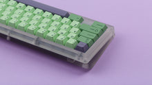 Load image into Gallery viewer, GMK CYL Zooted keycaps on translucent smoke 60% keyboard, close-up of bottom-right corner showing arrow keys, Shift, and purple modifier accents against a lavender background