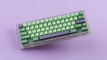 Load image into Gallery viewer, GMK CYL Zooted keycaps on translucent smoke 60% keyboard, top-down angled wide shot showing full compact layout with purple spacebar and accent modifiers on lavender surface