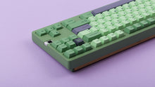 Load image into Gallery viewer, GMK CYL Zooted keycaps on green 1800 compact keyboard, close-up of left side showing Escape cluster and purple accent arrow keys against a lavender background