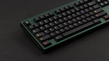 Load image into Gallery viewer, Keycapsule Prism dark on a green Keycult No. 1 angled close up on left side