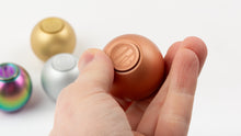 Load image into Gallery viewer, Copper orb held in hand with gold, silver, and rainbow orbs in background