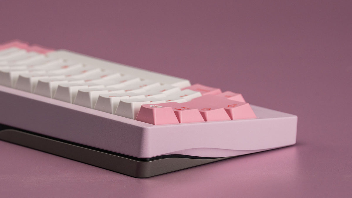  Close-up of a keyboard with pink and white keys on a purple background 