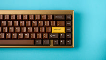 Load image into Gallery viewer, Render of GMK CYL Chocolatier keycaps on a cream keyboard, angled view highlighting the golden yellow accent keys
