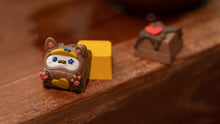Load image into Gallery viewer, render of CYL Chocolatier Choco-Cat resin artisan keycap — brown cat character with white face, blue star, and pink paw details