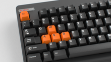 Load image into Gallery viewer, Render of GMK CYL Mini Orange Accent Pack keycaps on black Classic TKL keyboard, close-up of orange WASD and Esc keys