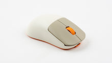 Load image into Gallery viewer, NK-M1 wireless gaming mouse in beige with orange scroll wheel and orange base, three-quarter top view