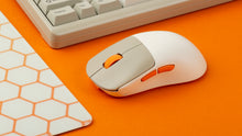 Load image into Gallery viewer, NK-M1 beige gaming mouse on an orange desk beside a glass mousepad and keyboard