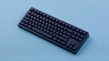 Load image into Gallery viewer, dark blue NK87 case with included dark milkshake themed keycaps monochrome